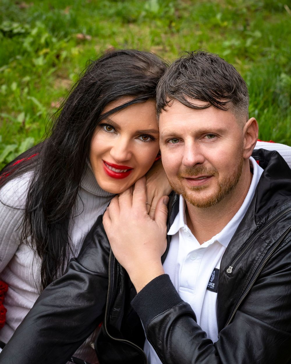 Stylish couple posing together outdoors in casual fall attire.