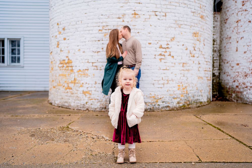 A sweet moment captured against a rustic brick wall background.