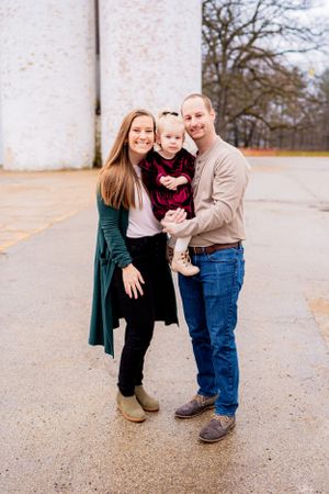 A family portrait against a white brick wall background.