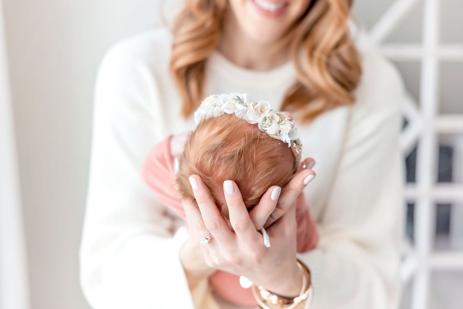 Close-up view of hands holding her newborn during a photography session in Mason City, Iowa.