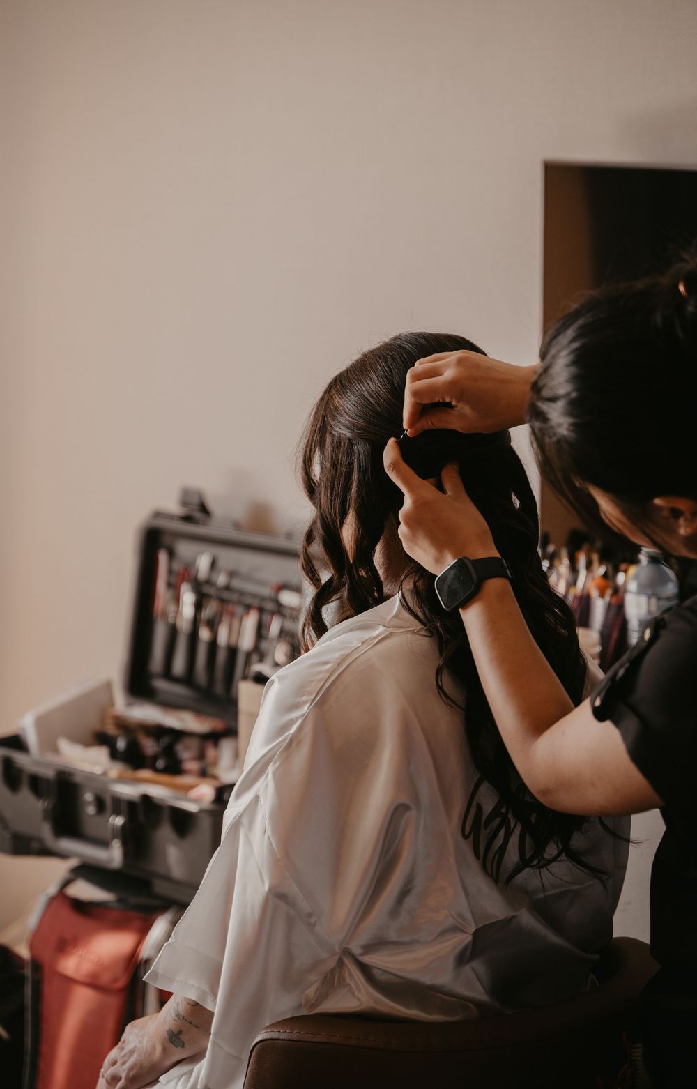 Getting ready scene with hair styling preparations in a dimly lit room.
