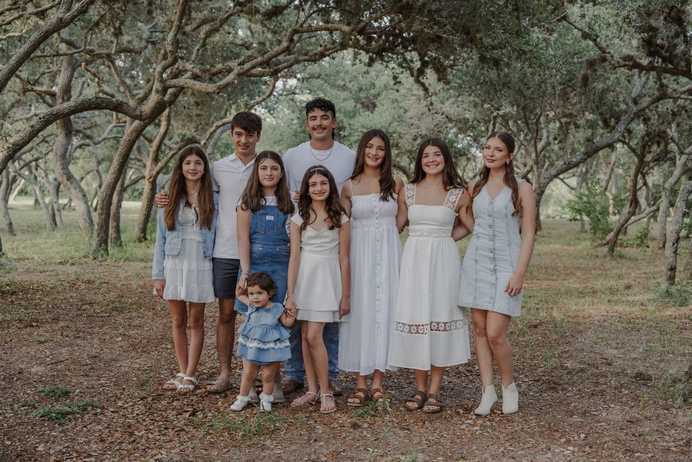 Group of people in coordinated white and blue outfits posing together outdoors.