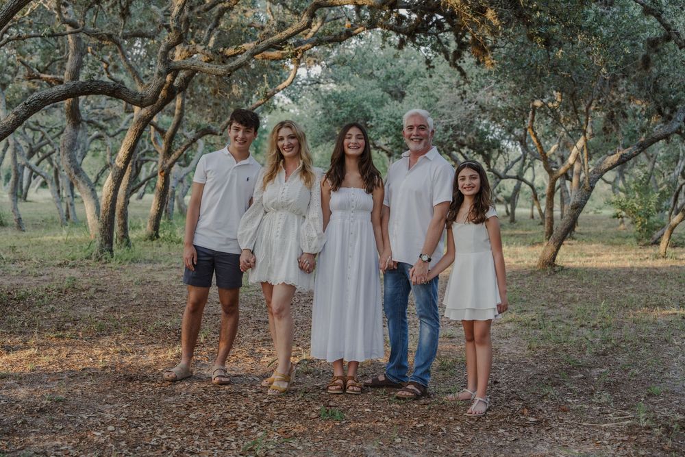 Group photo session in a natural woodland setting with coordinated casual attire.