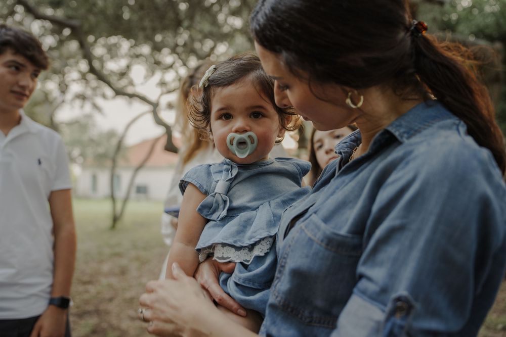 Parent and child sharing tender moment in matching denim outfits outdoors.