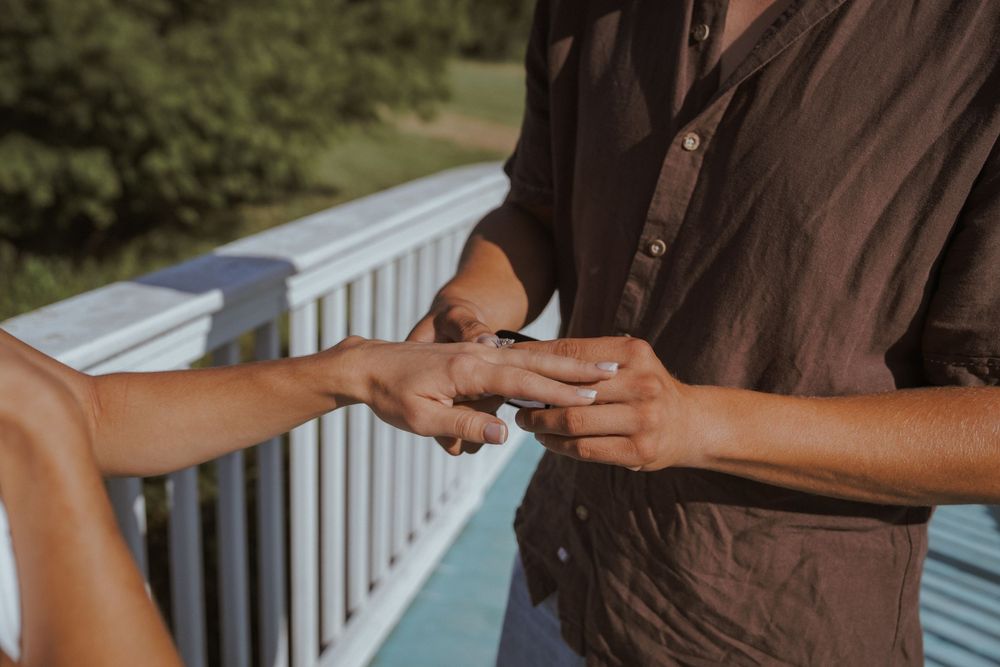 Intimate moment shared on a white porch railing during golden hour.