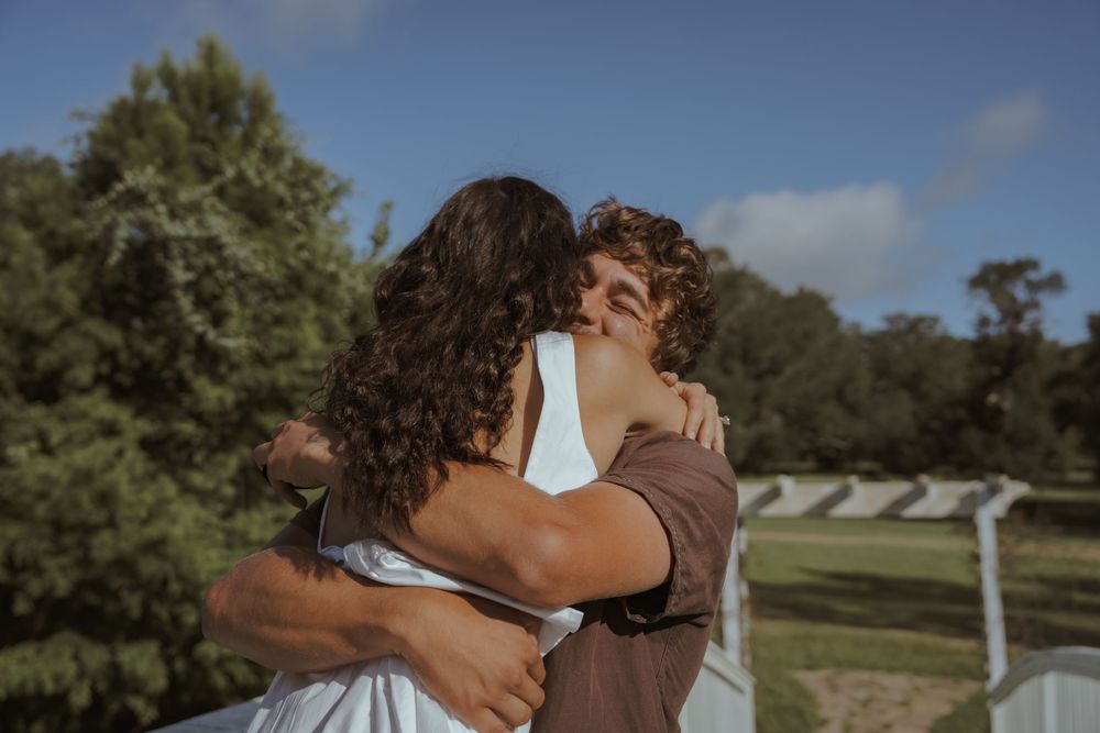 A romantic moment captured on a sunny day outdoors.