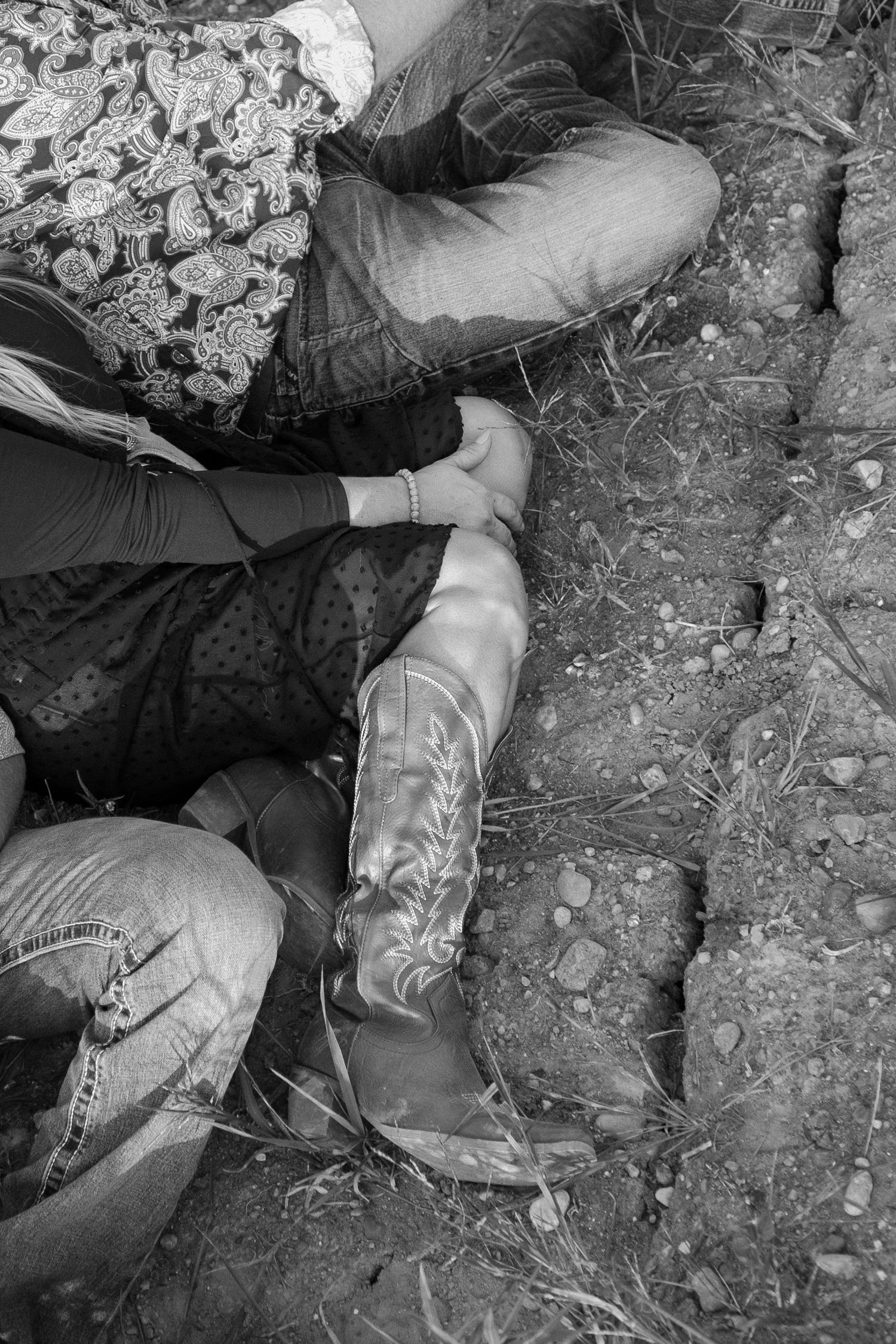 A sequence of black and white close-up photos showing hands working in rocky soil or dirt.