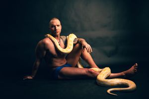 Utah male boudoir and fitness photography by Carl James Photography in Salt Lake City, featuring man posing with a yellow python snake.