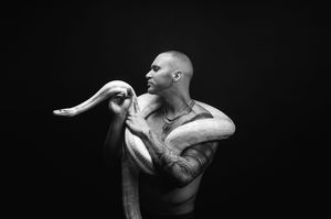 Utah male boudoir and fitness photography by Carl James Photography in Salt Lake City, featuring man posing with a yellow python snake. B&W