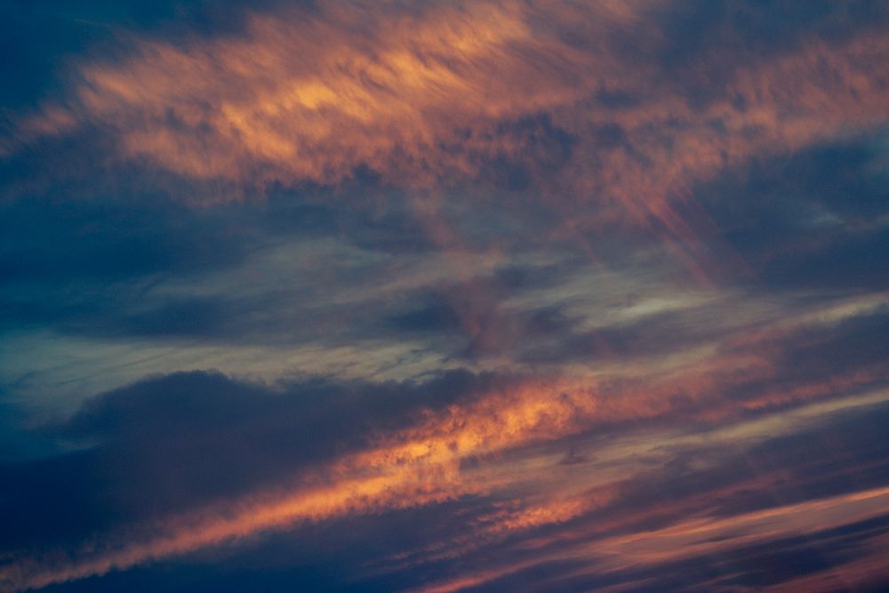 A stunning panoramic view of colorful sunset clouds stretching across a dramatic evening sky.