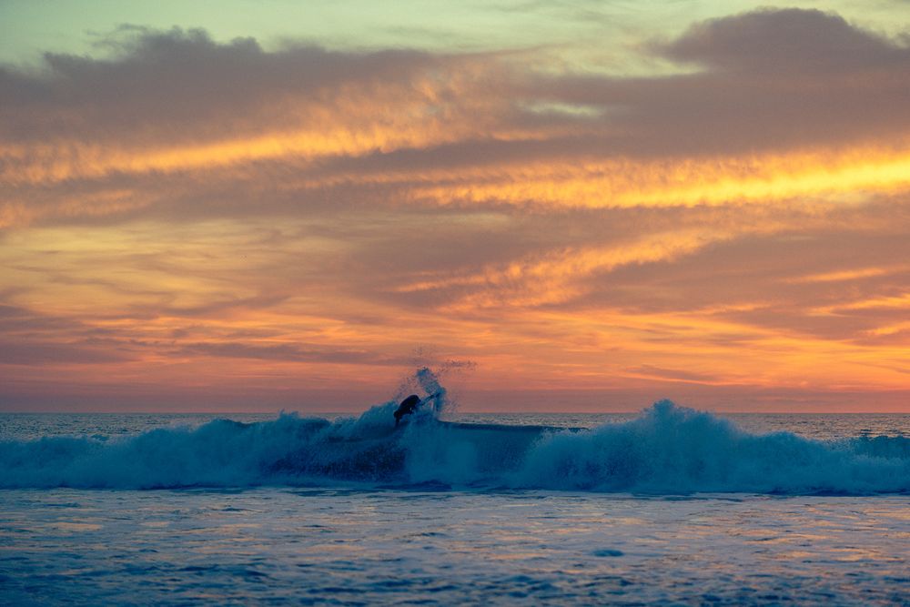 A series of seven stunning ocean sunset photos showing waves crashing and vibrant orange and purple skies over the water.