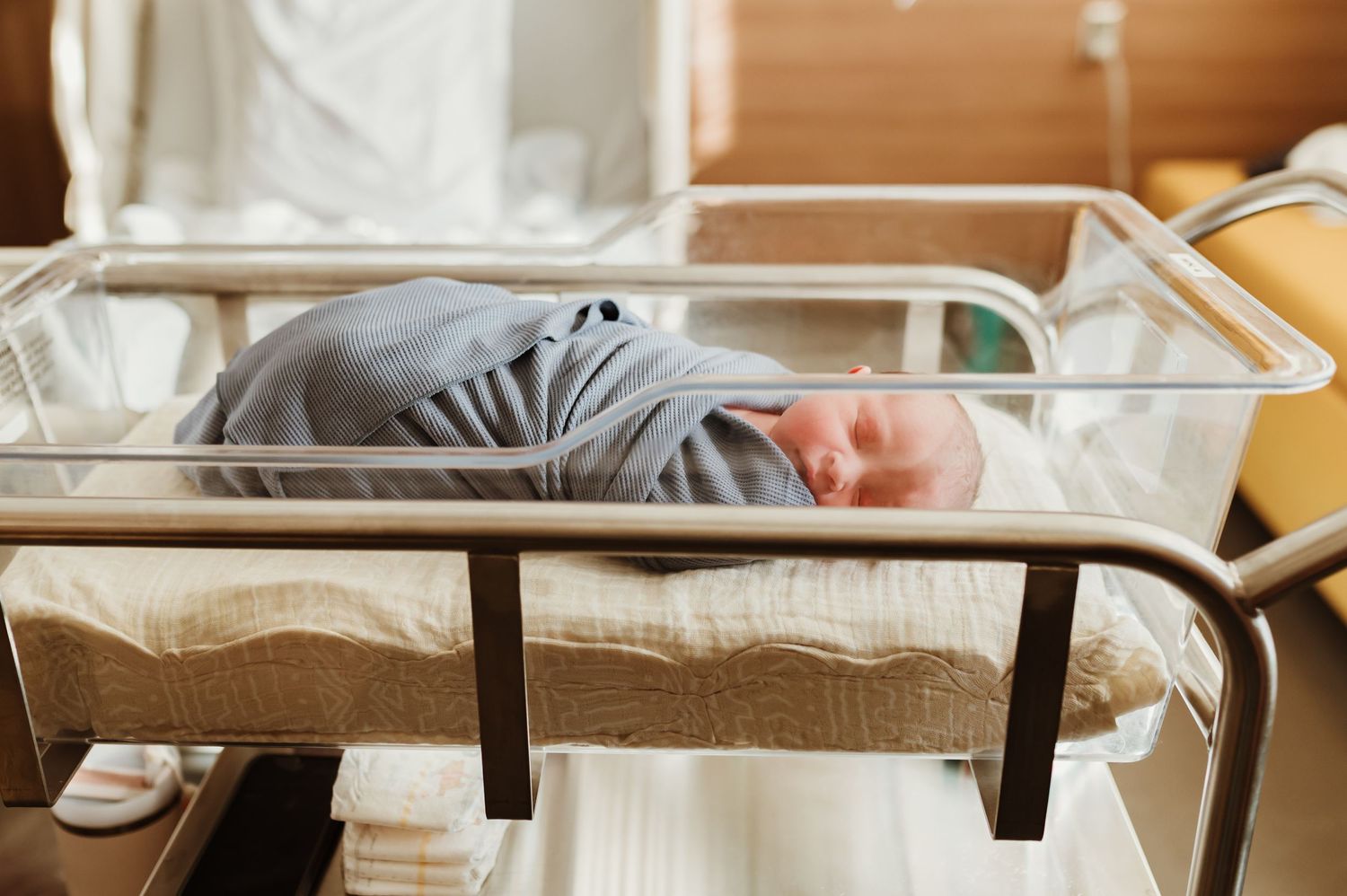 Newborn baby swaddled and sleeping in the hospital bassinet