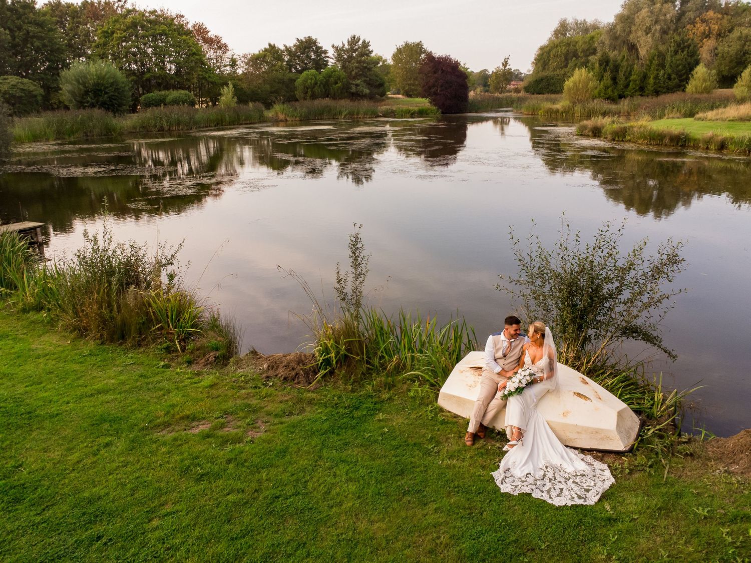 Scenic lakeside wedding photos taken at sunset with natural landscape reflections in the water.