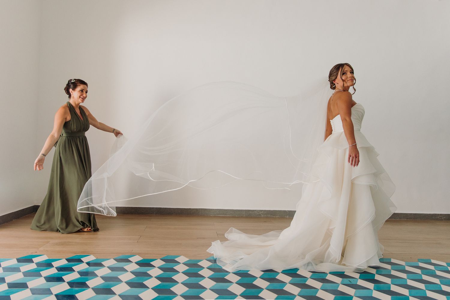 A dancer in an olive green dress performs an elegant spinning motion in a bright white studio space. El Dorado Royale Wedding Photographer
