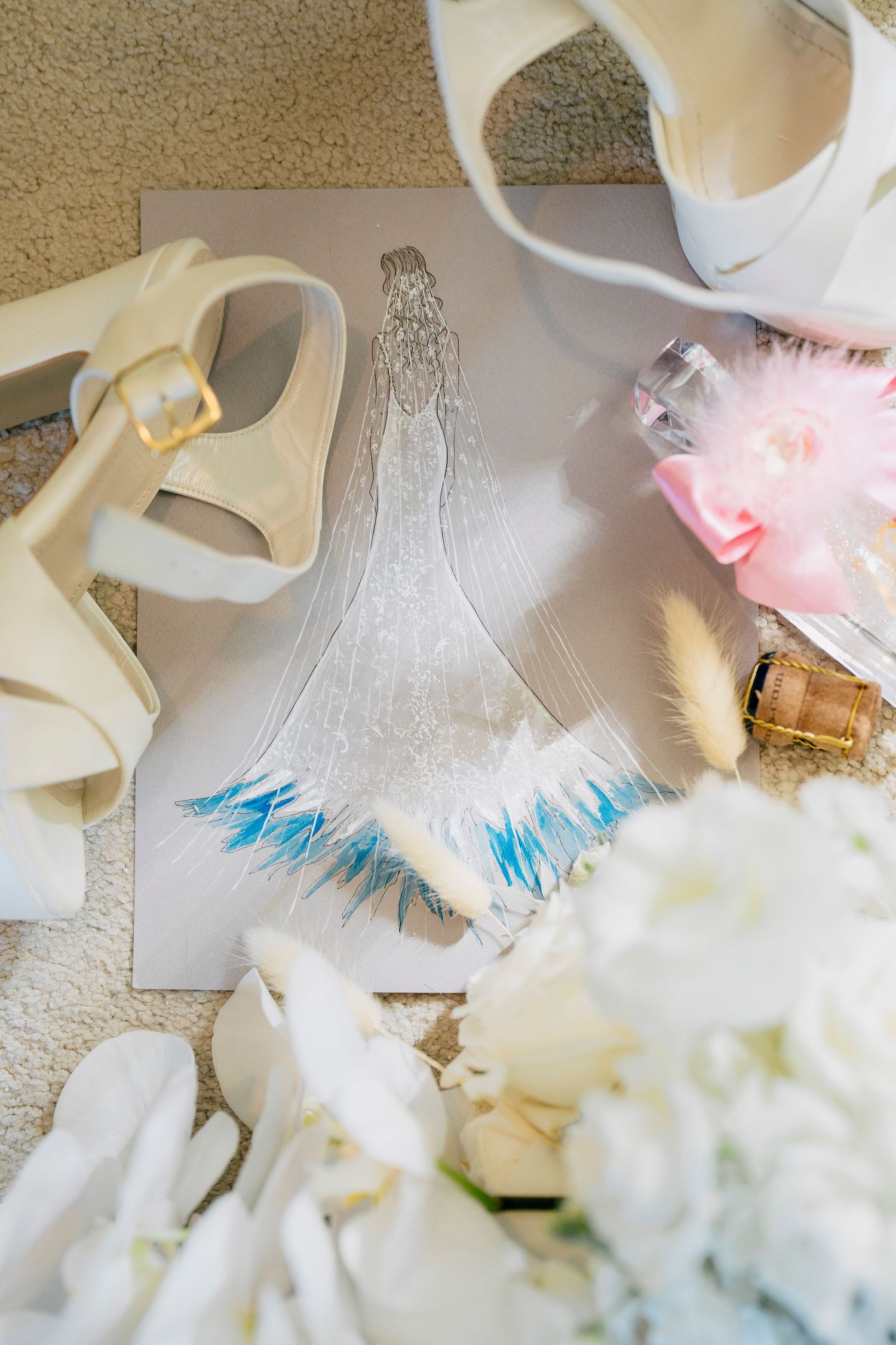 A series of white and blue feathered angel wings and crafting materials laid out on a beige carpet.
