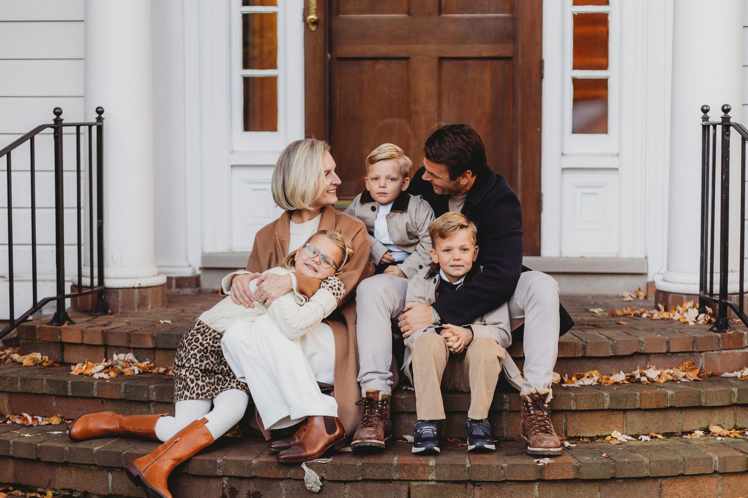 A series of candid moments showing children playing and sitting on white steps with autumn leaves scattered around.