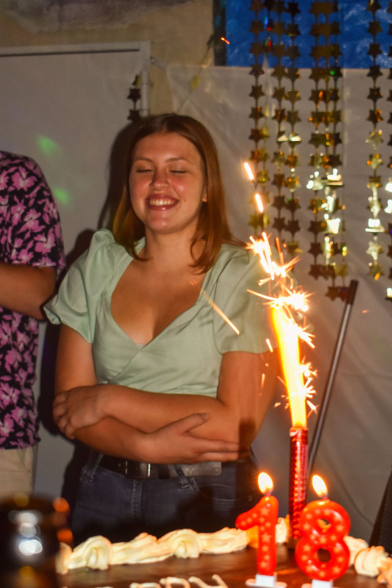 Birthday celebration with sparkling candles and decorative backdrop at a festive party.
