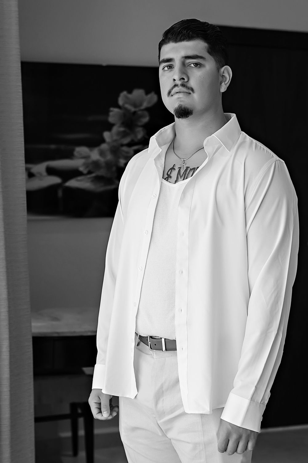 A black and white photograph showing someone in a crisp white dress shirt against a light background.