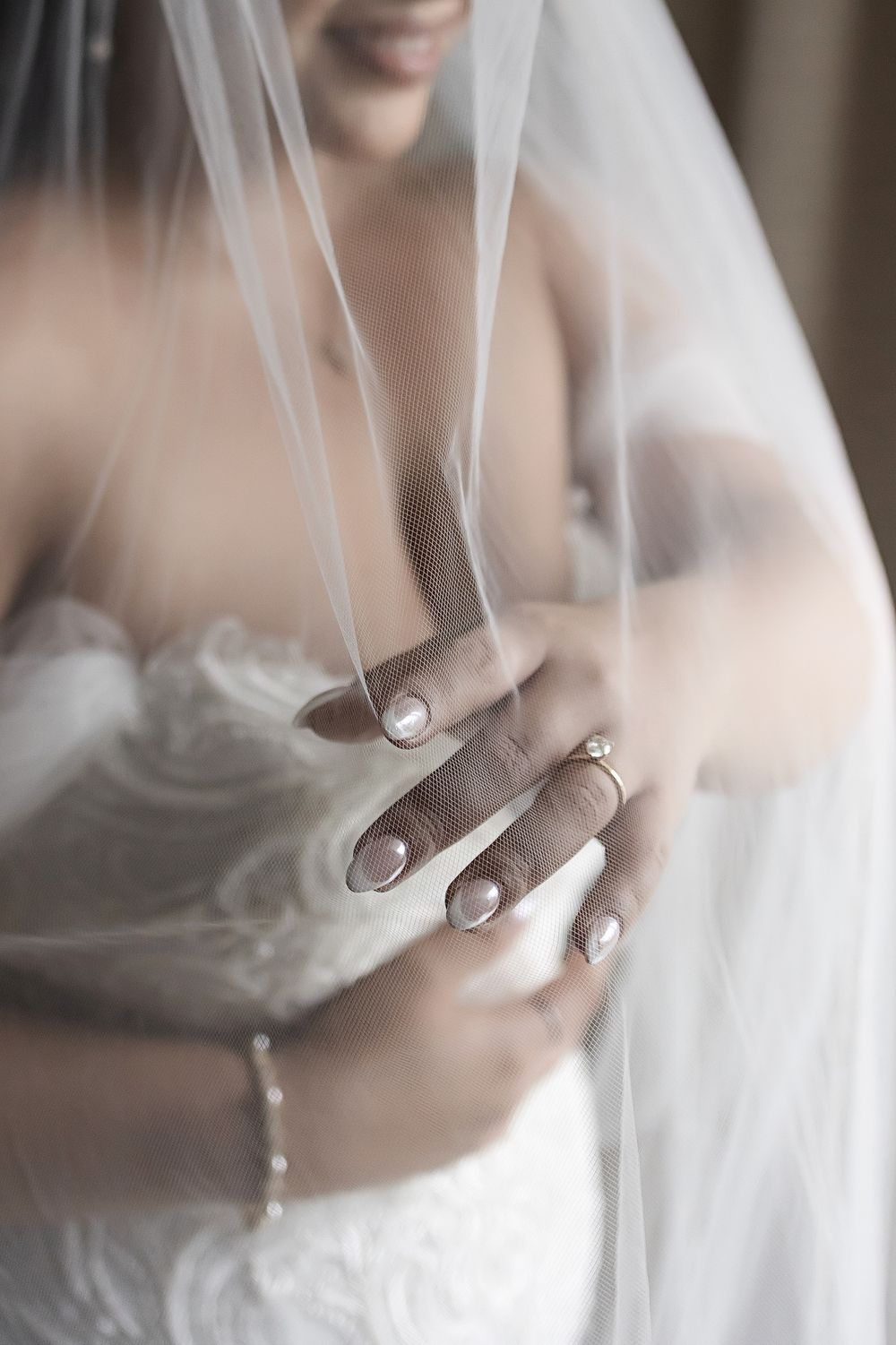 Close-up of the bride holding her veil and showing her engagement ring before the ceremony.