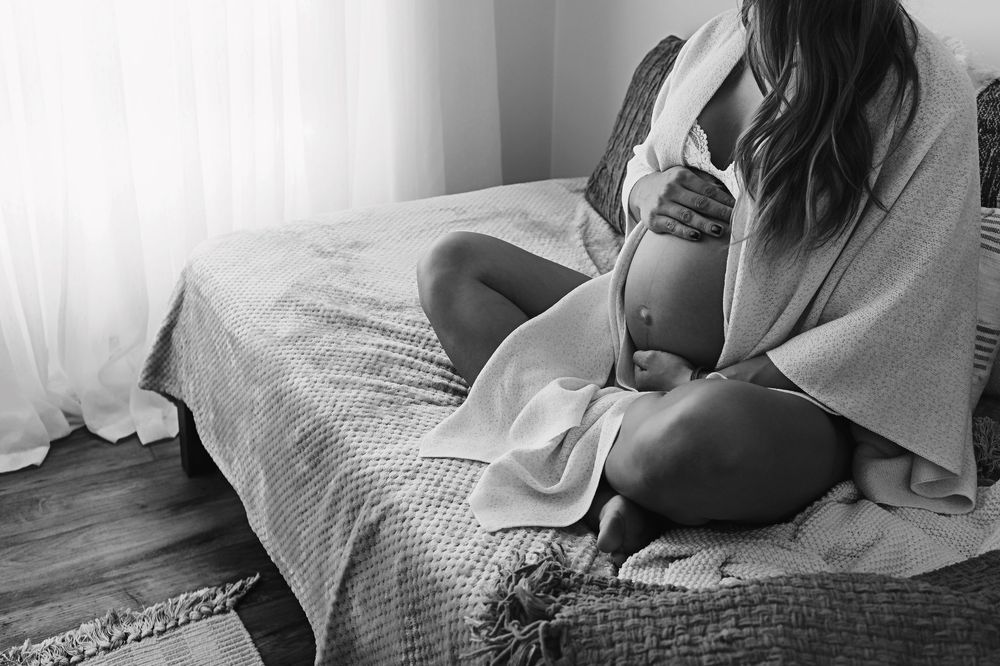 Pregnancy photo snuggling her belly.