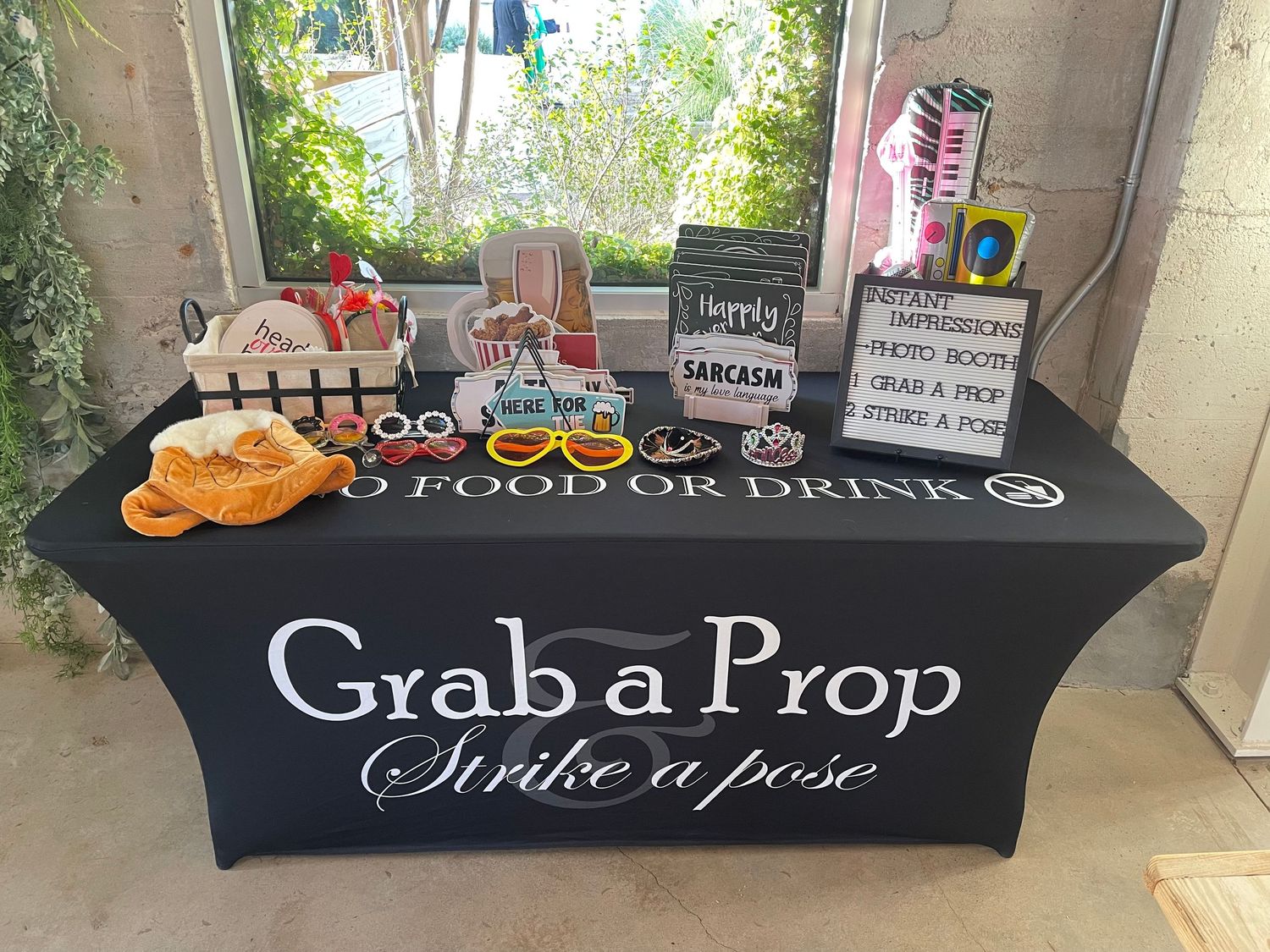 Grab a Prop Strike a Pose table display with fun photo booth props and accessories at a wedding event.