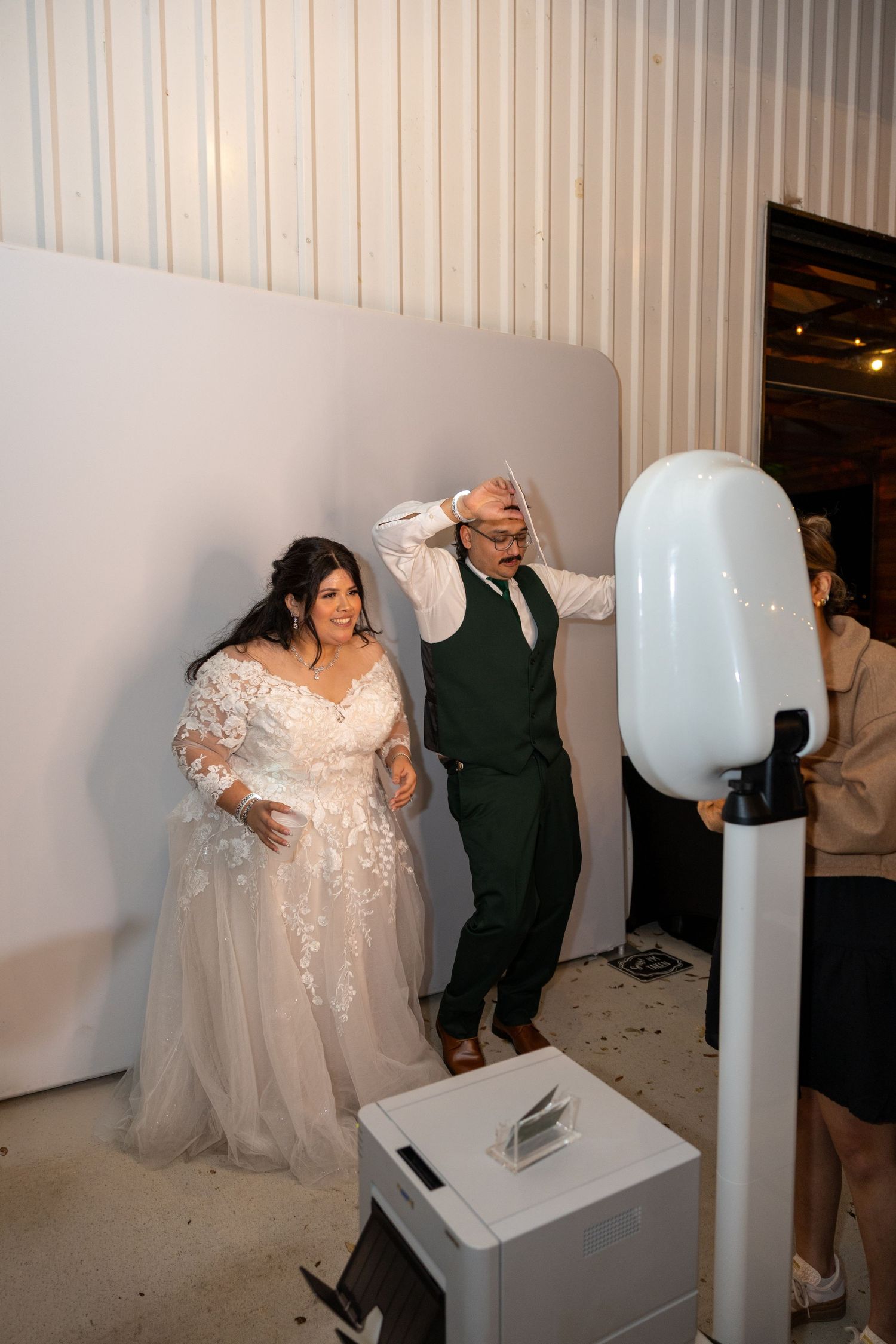 Bride and groom posing playfully at a wedding photo booth during their reception.