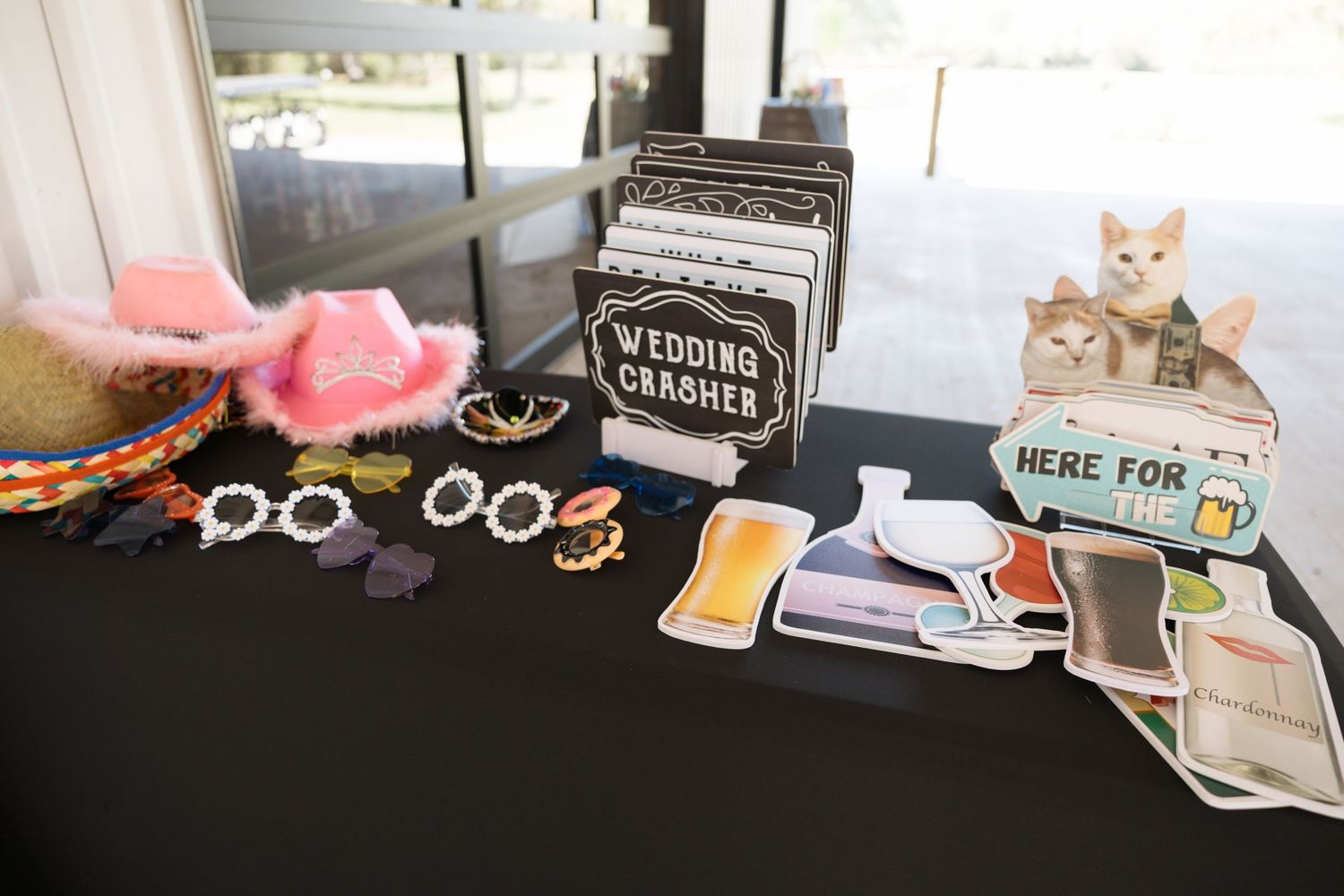 Wedding photo booth prop table with hats, glasses, and fun signs for guests.
