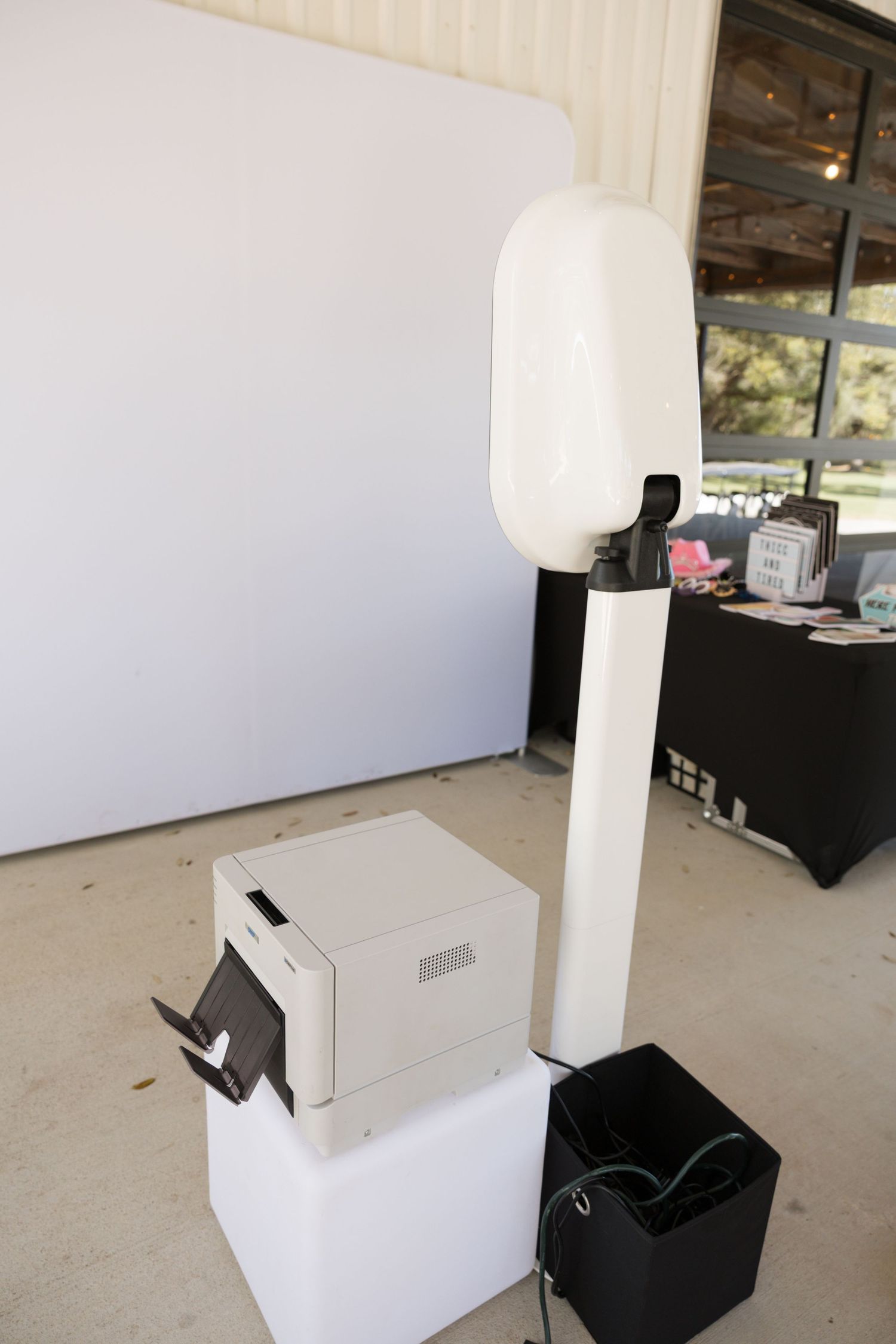 Professional wedding photo booth setup with camera, printer, and white backdrop.