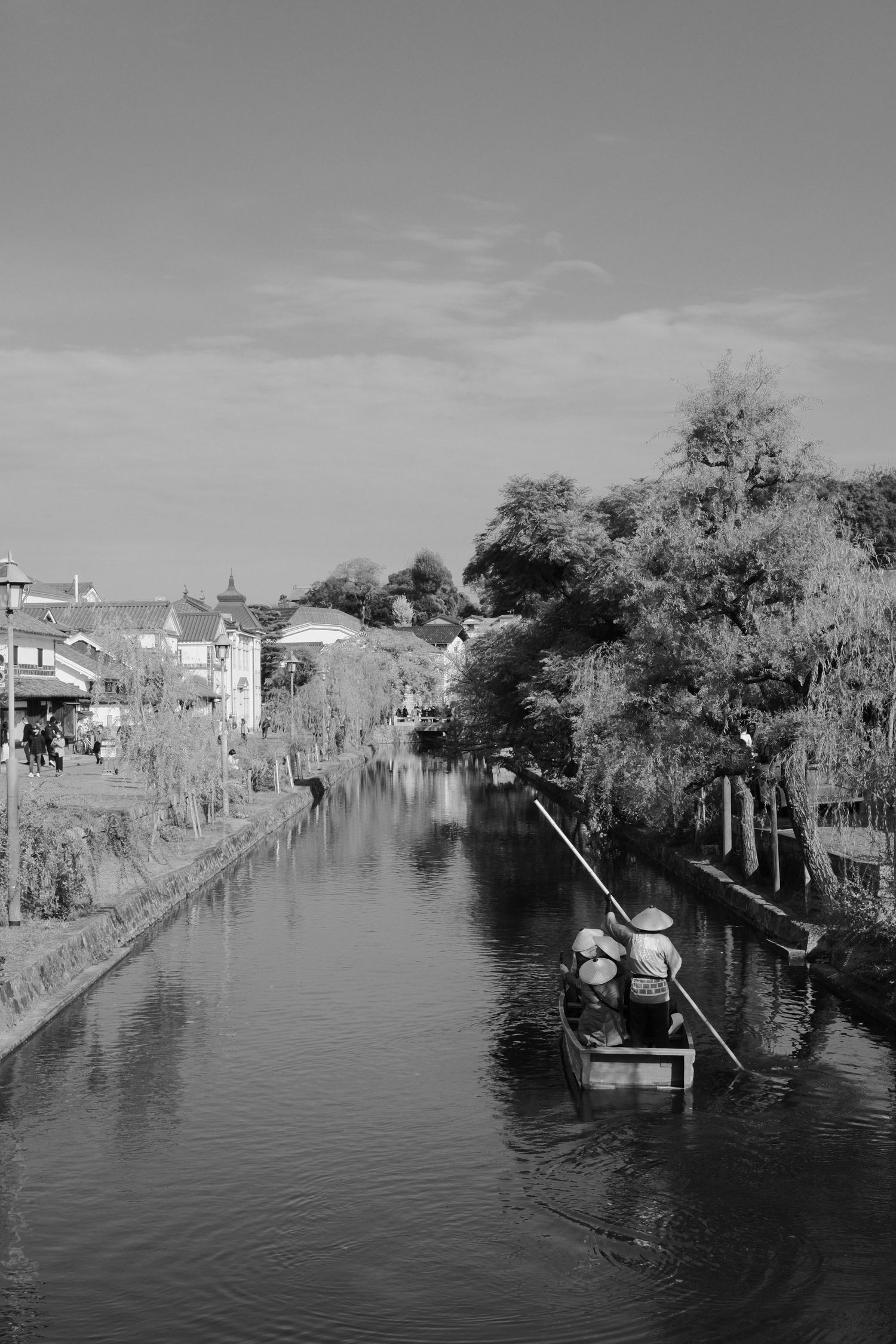 Black and white panoramic view of flooded houses and buildings along a waterway during a natural disaster.
