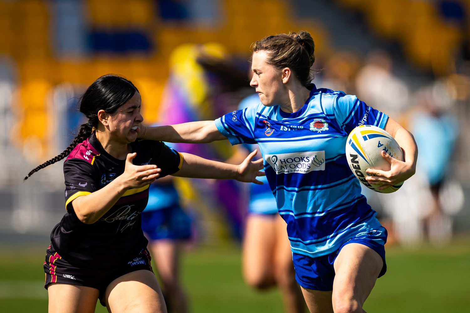 Rugby players in blue jerseys compete intensely during a professional match.