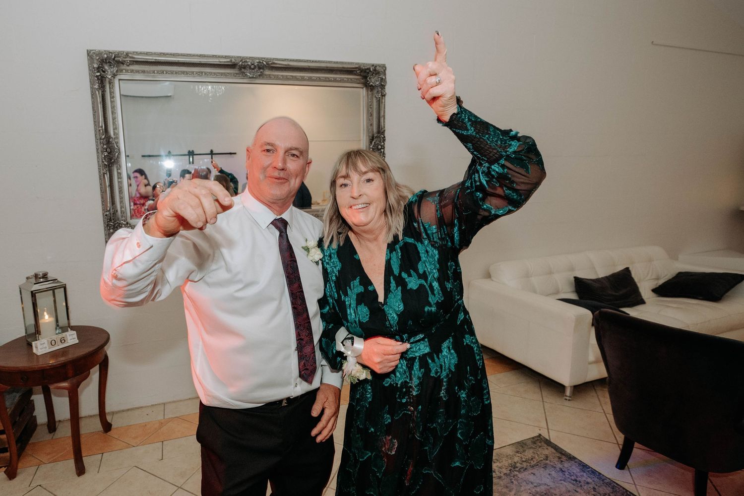 Two people in formal attire dance together at an indoor celebration event with joyful expressions.