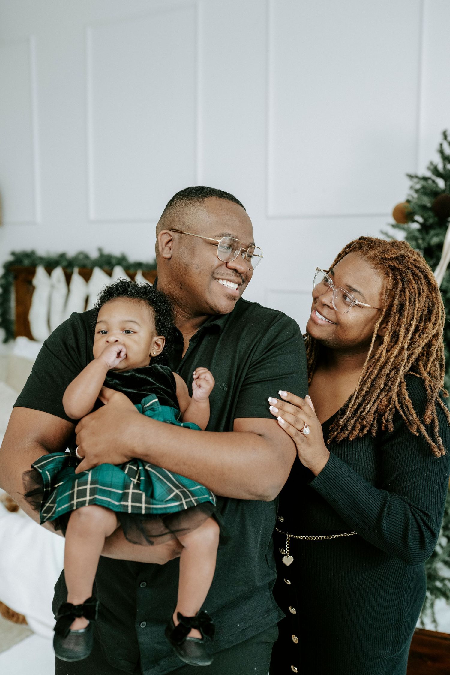 A series of candid family photos showing joyful moments and embraces against a white wall with holiday decorations.