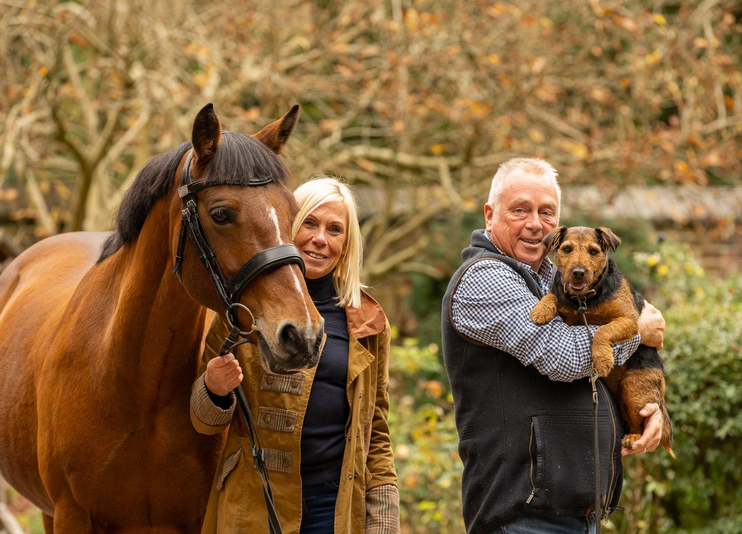 A horse and its rider enjoy an outdoor photoshoot session near rustic wooden fencing on a sunny day.