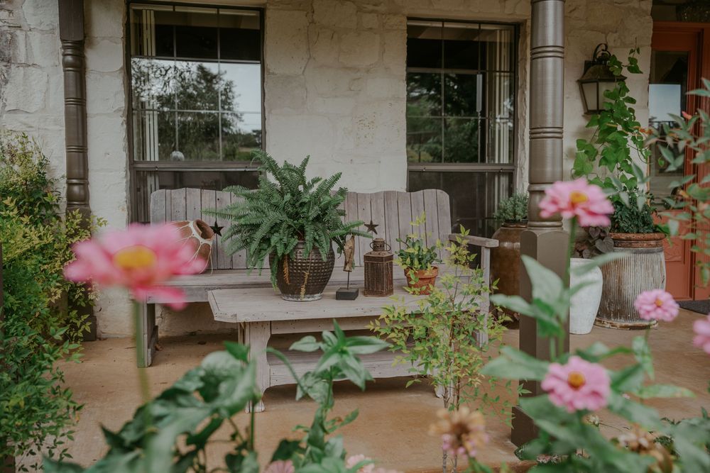 Stone patio with potted plants and pink flowers creating a serene garden atmosphere.
