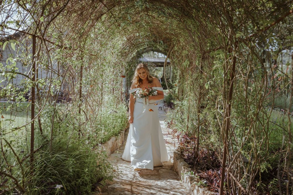 Garden pathway with natural greenery and trees creating romantic wedding setting.