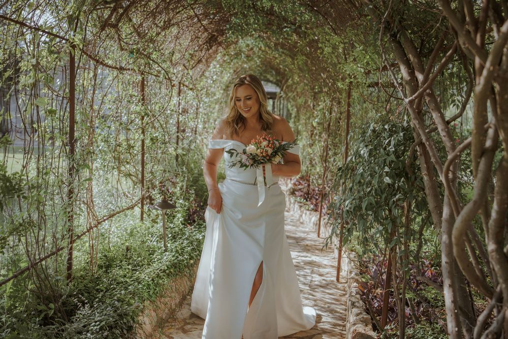 A romantic forest path with sunlight streaming through the trees creates a dreamy wedding day atmosphere.