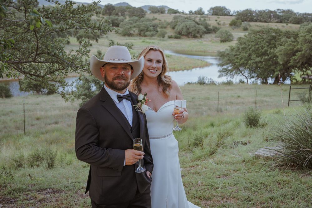 Wedding celebration in a scenic countryside setting with rolling hills and trees.
