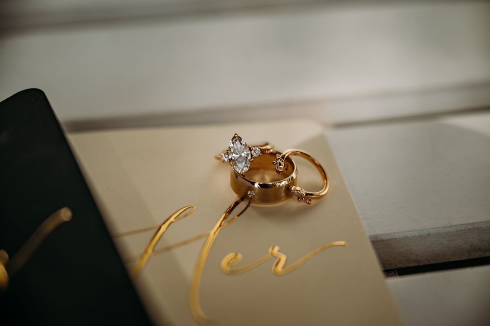 Gold wedding rings and elegant calligraphy on cream-colored stationery.