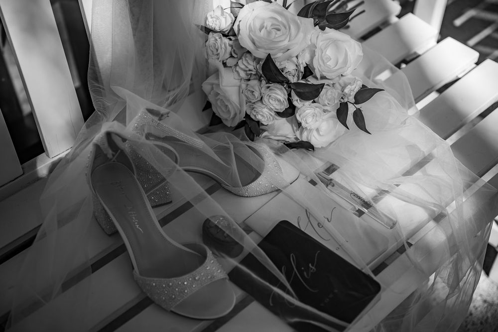 Black and white detail shot of wedding accessories and floral arrangements.