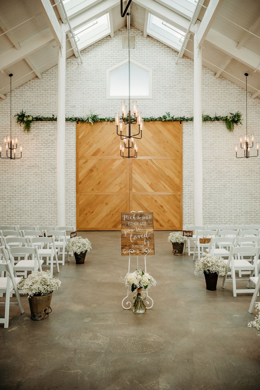 Modern chapel interior with vaulted ceiling, white brick walls and chevron wood accent wall.