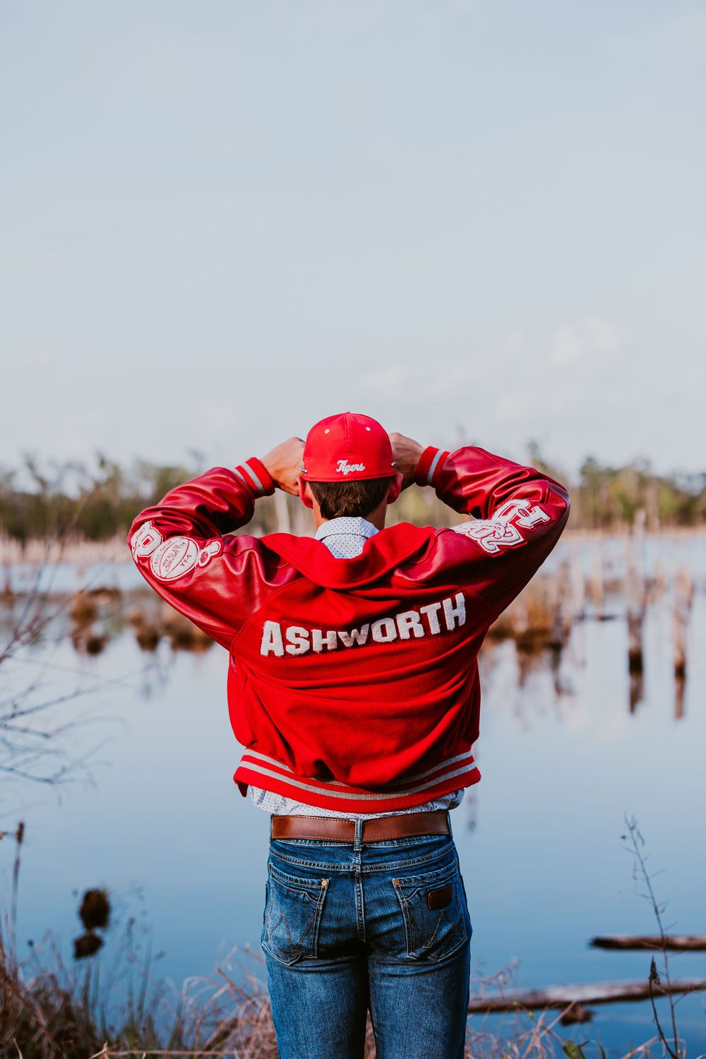 Back view of person wearing red Ashworth jacket by water.