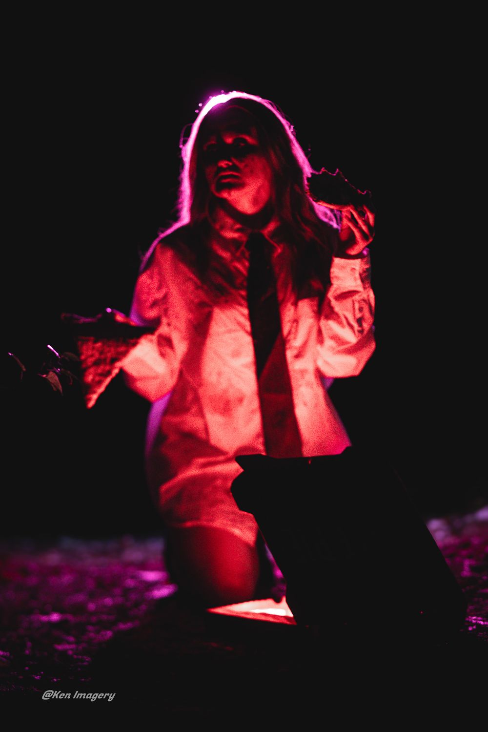 A figure illuminated in dramatic red lighting poses against a dark background in a series of artistic photographs.