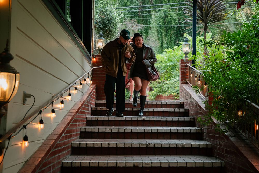 Evening gathering under a lit pergola with string lights creating an intimate atmosphere.