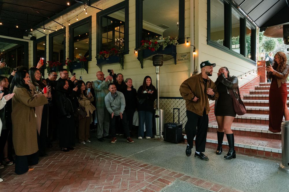 People gathered under a covered walkway during an outdoor evening event.