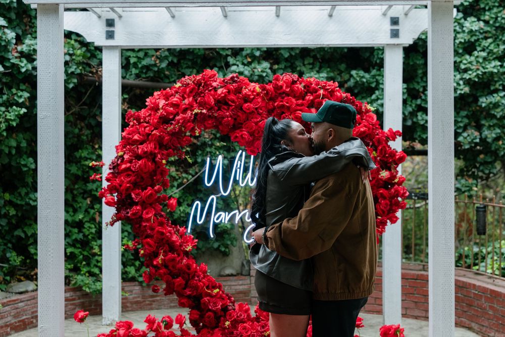 Garden pergola with spectacular red rose arrangements and illuminated signage.