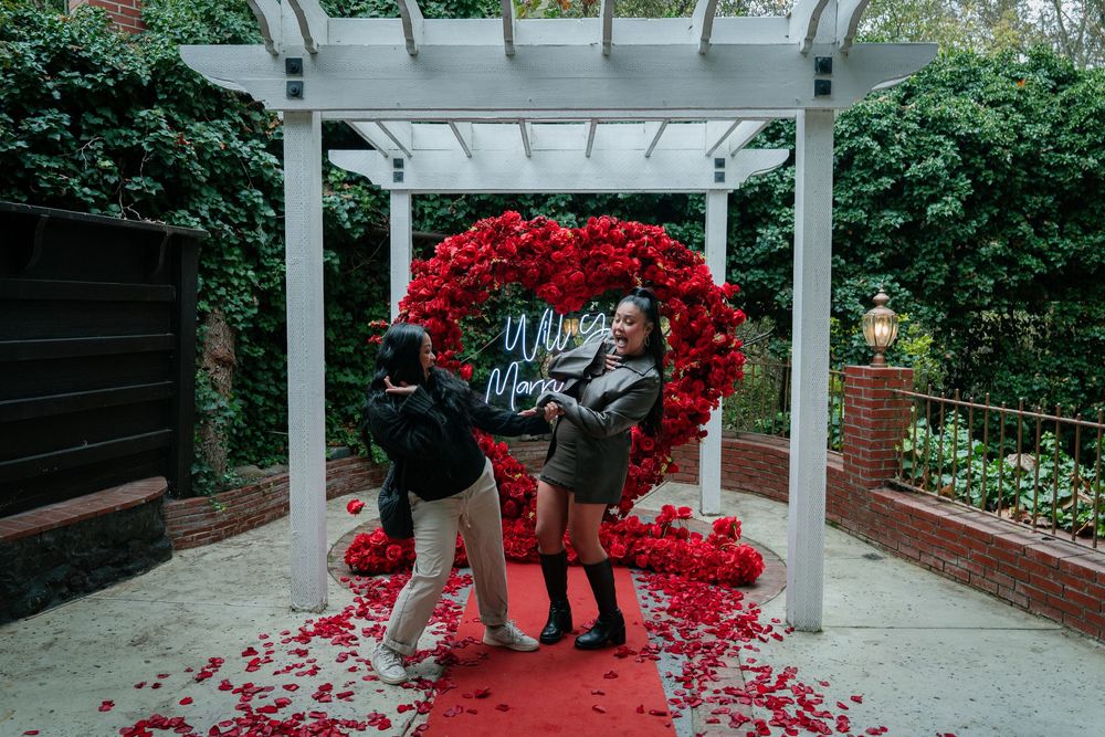 White pergola walkway decorated with cascading red flowers creates an elegant outdoor path.