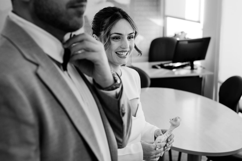 Black and white photo of two business colleagues sharing a joyful moment during a meeting at the office.
