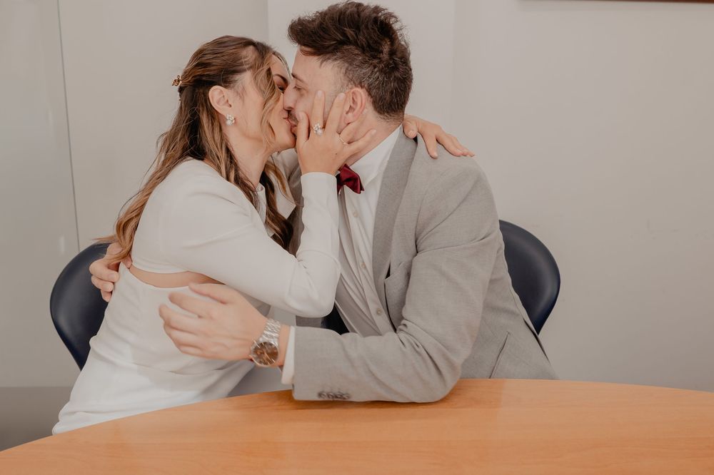 A series of photos showing a couple kissing while sitting at a wooden table in an office setting.
