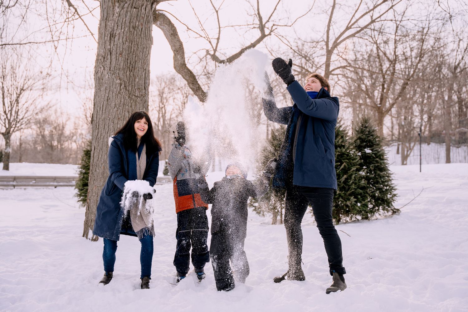 Seance photo de famille dans la neige en hiver au parc du Mont-Royal à Montreal.