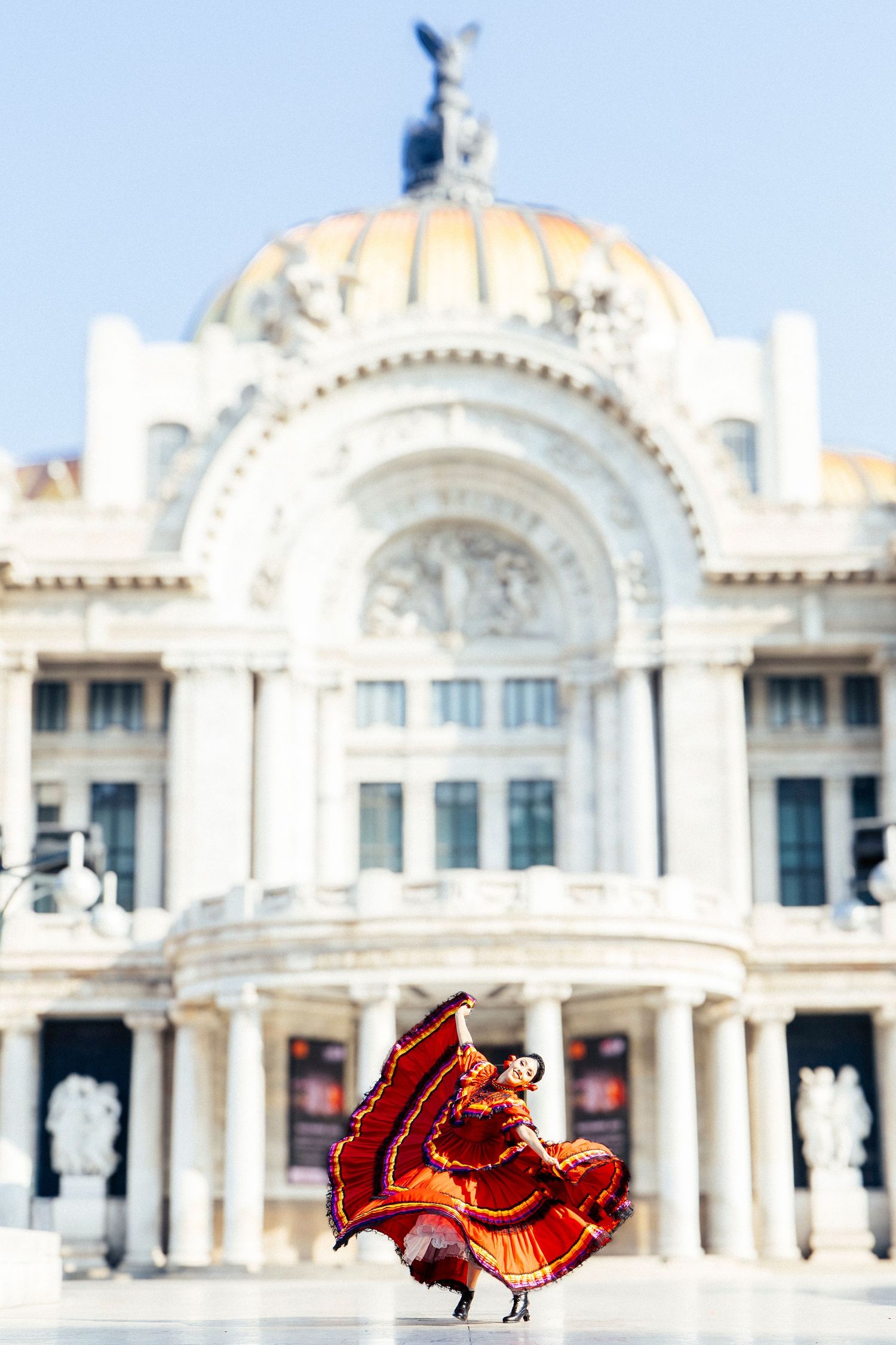 Ballet Folklórico de México dancer performing traditional movement outside Palacio de Bellas Artes